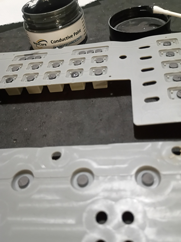 Applying the conductive paint to the silicon button sheets.